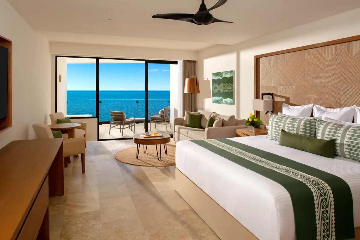 Club Junior Suite Ocean Front with king bed, sofa area, and private oceanfront balcony at Dreams Sapphire Resort & Spa.