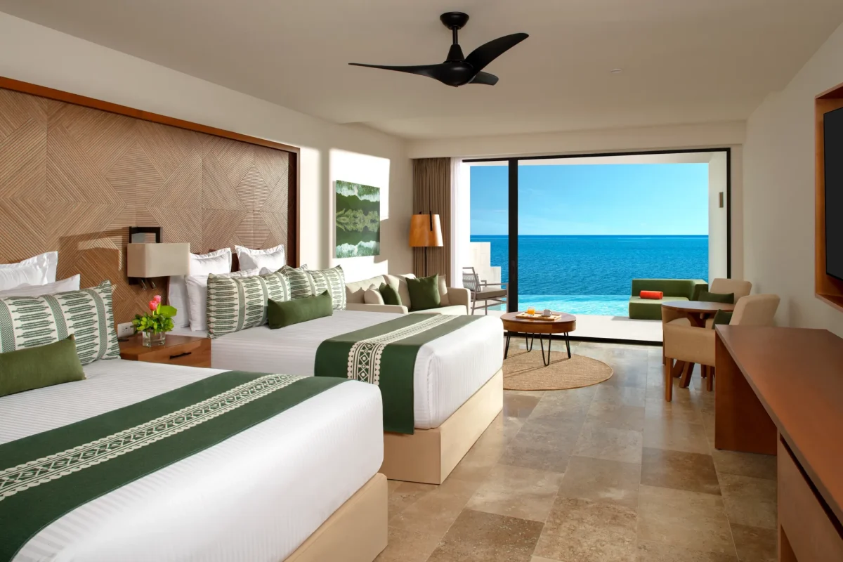 Club Junior Suite Ocean Front Swim Out Double with two double beds, direct pool access, and Caribbean Sea views at Dreams Sapphire Resort & Spa.