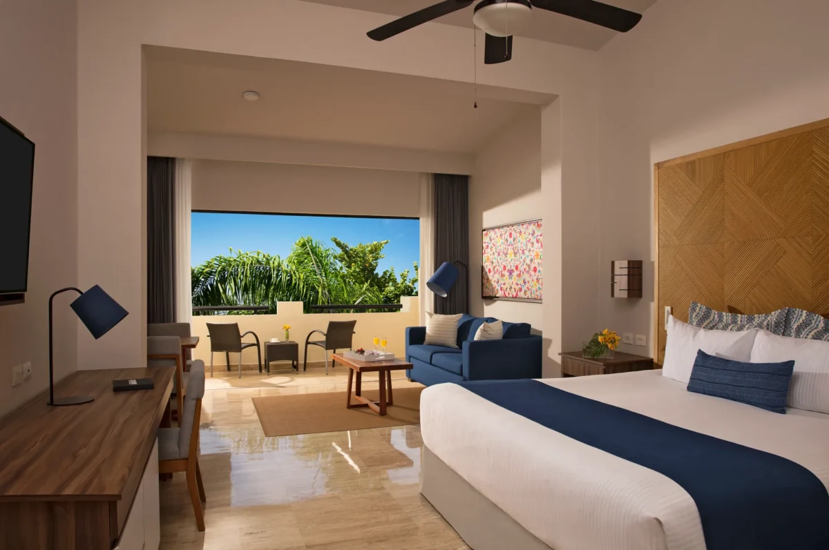 Deluxe Junior Suite Tropical View with king bed and private balcony at Dreams Sapphire Resort & Spa.