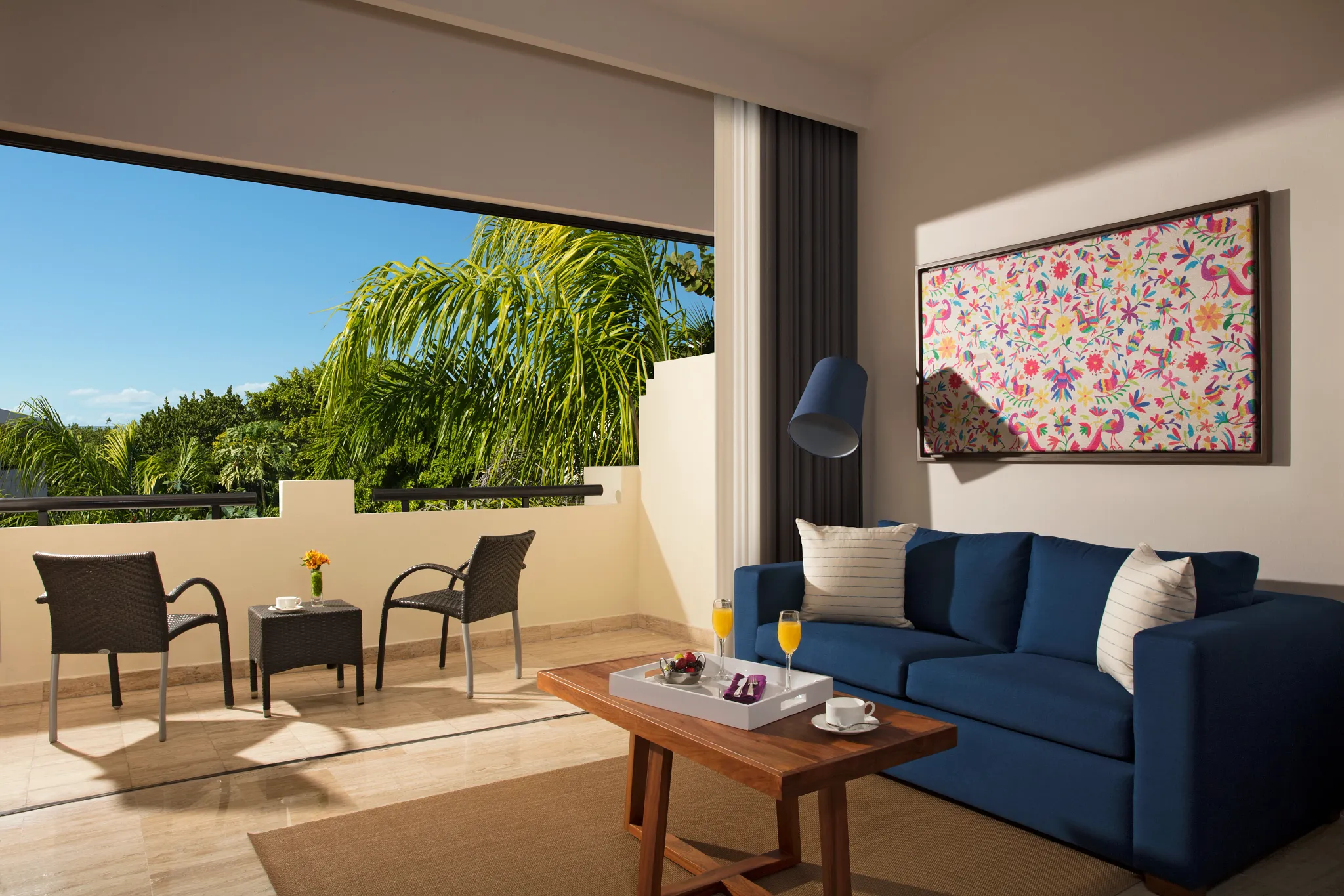 Preferred Club Family Junior Suite Tropical View living area with sofa and spacious private terrace at Dreams Sapphire Resort & Spa.